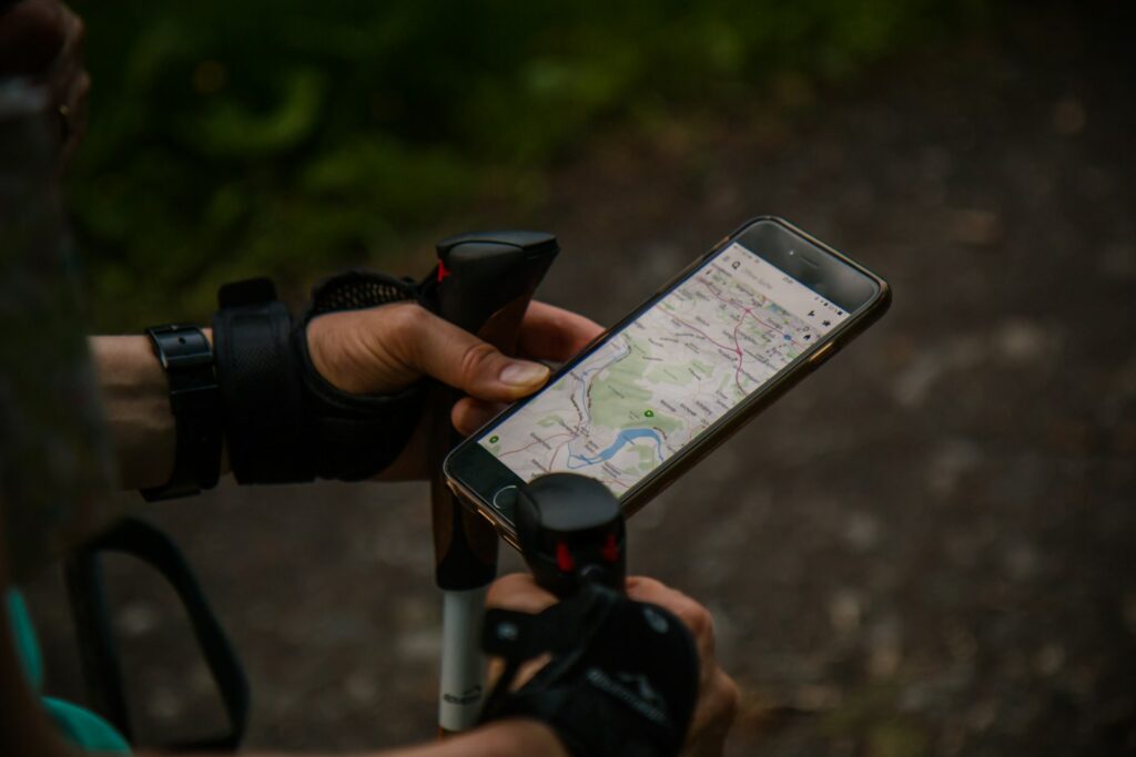 Person använder mobilen under en promenad med stavar